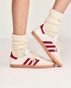 White and green/red Sporty & Rich retro sneakers with gum sole and vintage design.