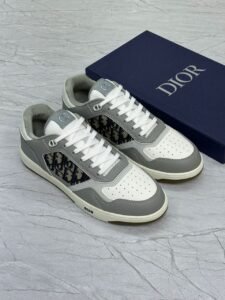 Black Dior B27 Low-Top Sneakers with Dior Oblique monogram and white laces placed beside branded blue Dior box on marble surface