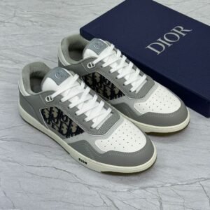 Black Dior B27 Low-Top Sneakers with Dior Oblique monogram and white laces placed beside branded blue Dior box on marble surface